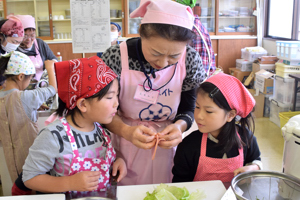 食生活改善推進委員に手伝ってもらう児童の画像