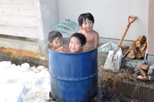 ドラム缶風呂に浸かる参加者の画像