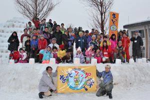 雪山の前で集合写真を撮っている画像