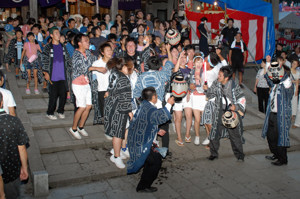 神社の前で木遣りを歌う若者の画像