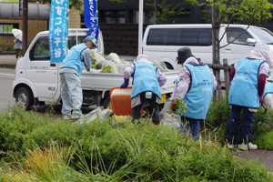 軽トラックで草を集めている画像