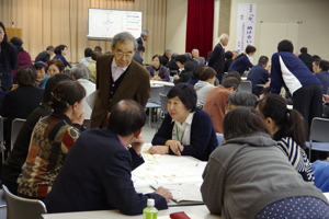 グループで交わされる意見に耳を傾ける堀田力会長の画像