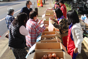 野菜を売っている中学生の画像