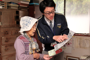 困りごと相談のチラシを手渡して説明する社会福祉協議会職員の画像