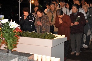 中越地震の日に合わせ慰霊の花を献花する人々の画像