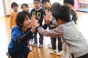 先生とハイタッチをする男の子の画像