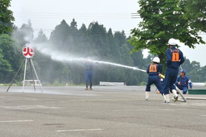 的に向かって放水する消防団員の画像