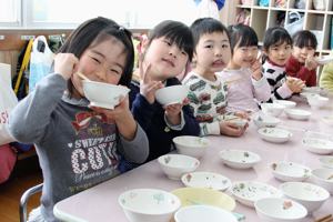 おいしそうにお雑煮を食べる園児の画像