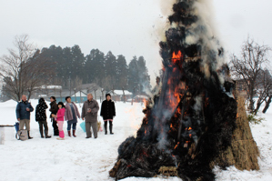 燃える炎を見守る住民の画像