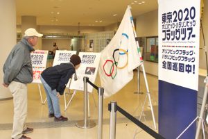 オリンピック・パラリンピックの旗を見る来場者の画像