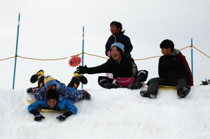 雪のすべり台をすべる子どもたちの画像