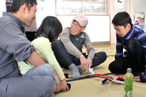 子どもたちに楽しそうに教える名人の画像