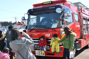 消防車両と記念写真を撮る親子の画像