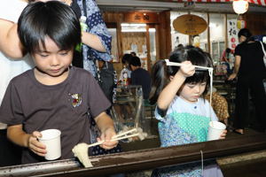 流しそうめんを食べる子どもの画像