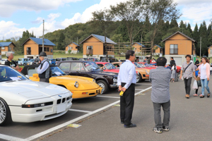 クラシックカーを見る来場者の画像