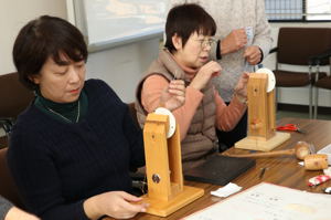 糸と針を使い皮を縫い合わせる参加者の画像