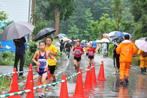 3キロメートルコースで雨の中を駆け抜ける参加者の画像