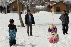 雪上ブランコで遊ぶ子どもの画像