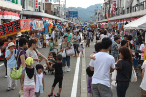 大勢の人で賑わうおまつり広場の画像