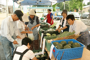 たくさんの野菜を購入するお客さんの画像