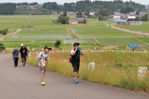 水分をとりながら山本山を上る参加者の画像