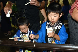 流しそうめんを食べる子どもの画像