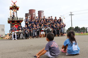 花火筒モニュメントの前で写真を撮る片貝中学校卒業生の画像