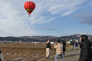 熱気球と一緒に写真を撮っている人の画像