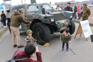 自衛隊車両の前で写真を撮る子どもたちの画像