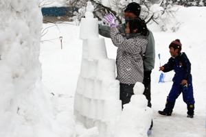 雪灯ろうを作る子どもの画像