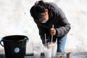 雪をかき混ぜる参加者の画像