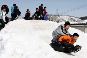 タイヤチューブ滑降で遊ぶ子どもたちの画像