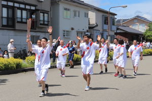 沿道に手を振る小千谷闘牛振興協議会のランナーの画像