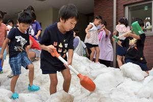 スコップで雪を掘る子どもたちの画像