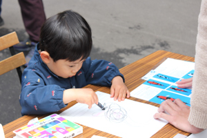 錦鯉のぬりえをする子どもの画像