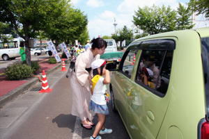 園児と小千谷縮を着た女性が交通安全を呼びかける画像