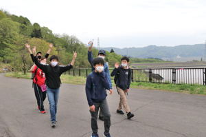 貯水池の近くの道路を楽しそうに歩く参加者の画像