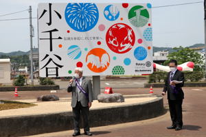 看板の前で話す小見山実行委員長の画像