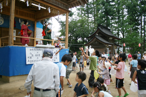 神楽を踊りながら餅をまく画像