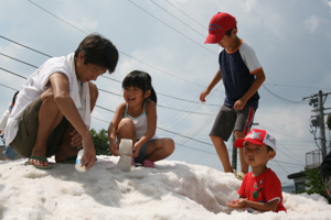 雪山で遊ぶ親子の画像