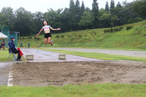 中学生女子が幅跳びをしている画像