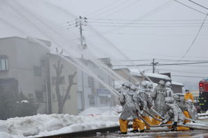 一斉放水訓練を行う消防団の画像