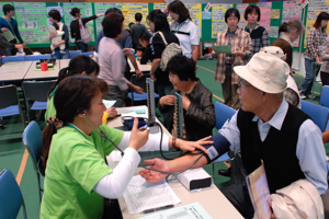 血圧を測定してもらう来場者の画像