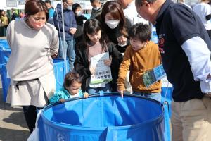 水槽をのぞき込む家族の画像