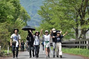 自然豊かなコースを笑顔で歩く参加者の画像