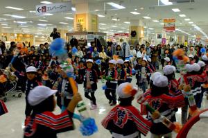 踊りを披露する園児と集まった大勢の観客の画像