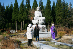 お釈迦様の前で記念写真を撮る参加者の画像