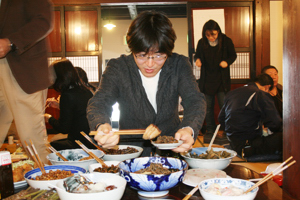 田舎料理を皿に取る参加者の画像