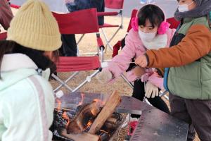 アウトドア体験広場でマシュマロを焼いている子どもたちの画像