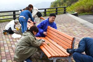 沢山ポケットパークのベンチを修繕する市民と職員の画像